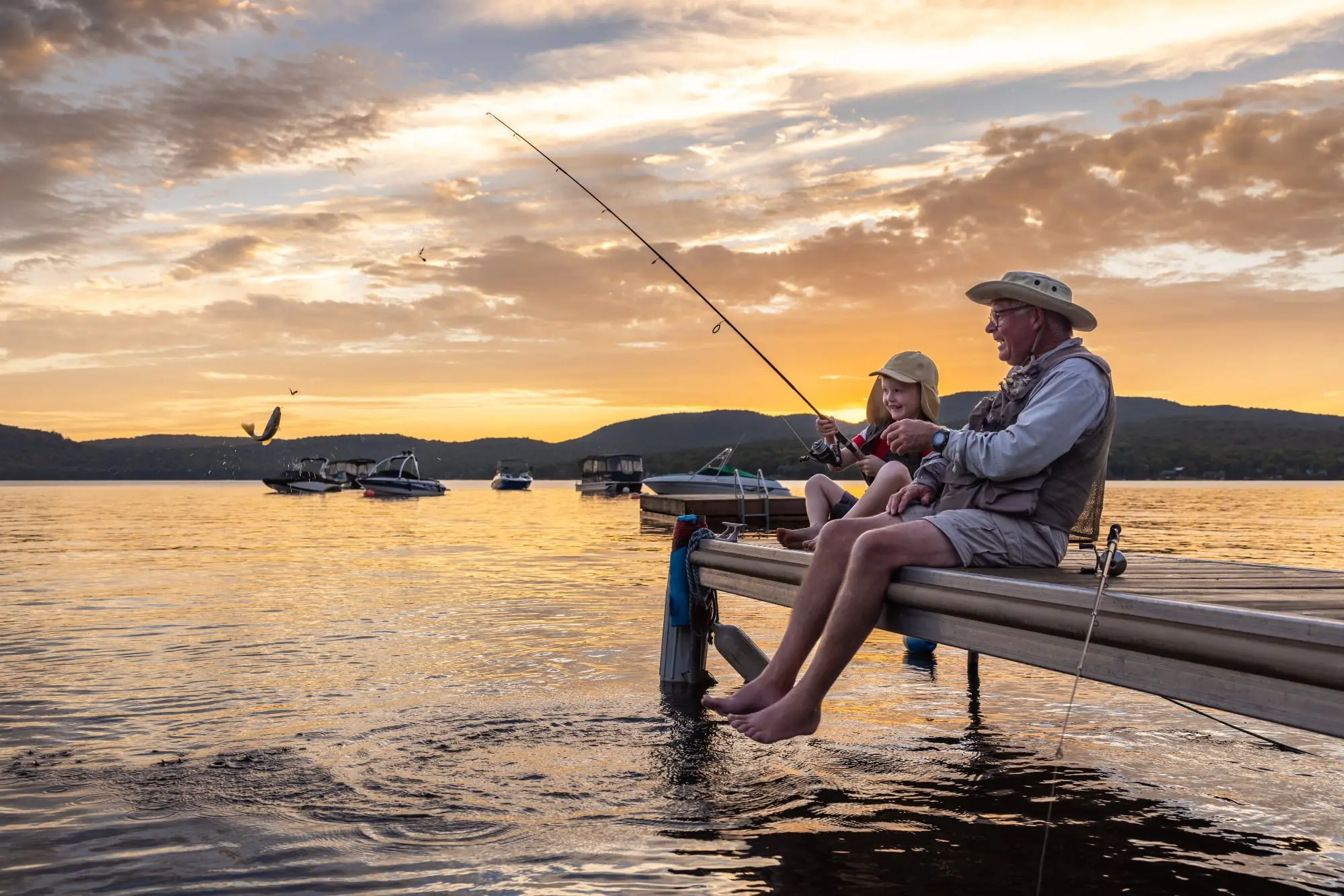 Grandfather and grandson
        catching fish on a dock